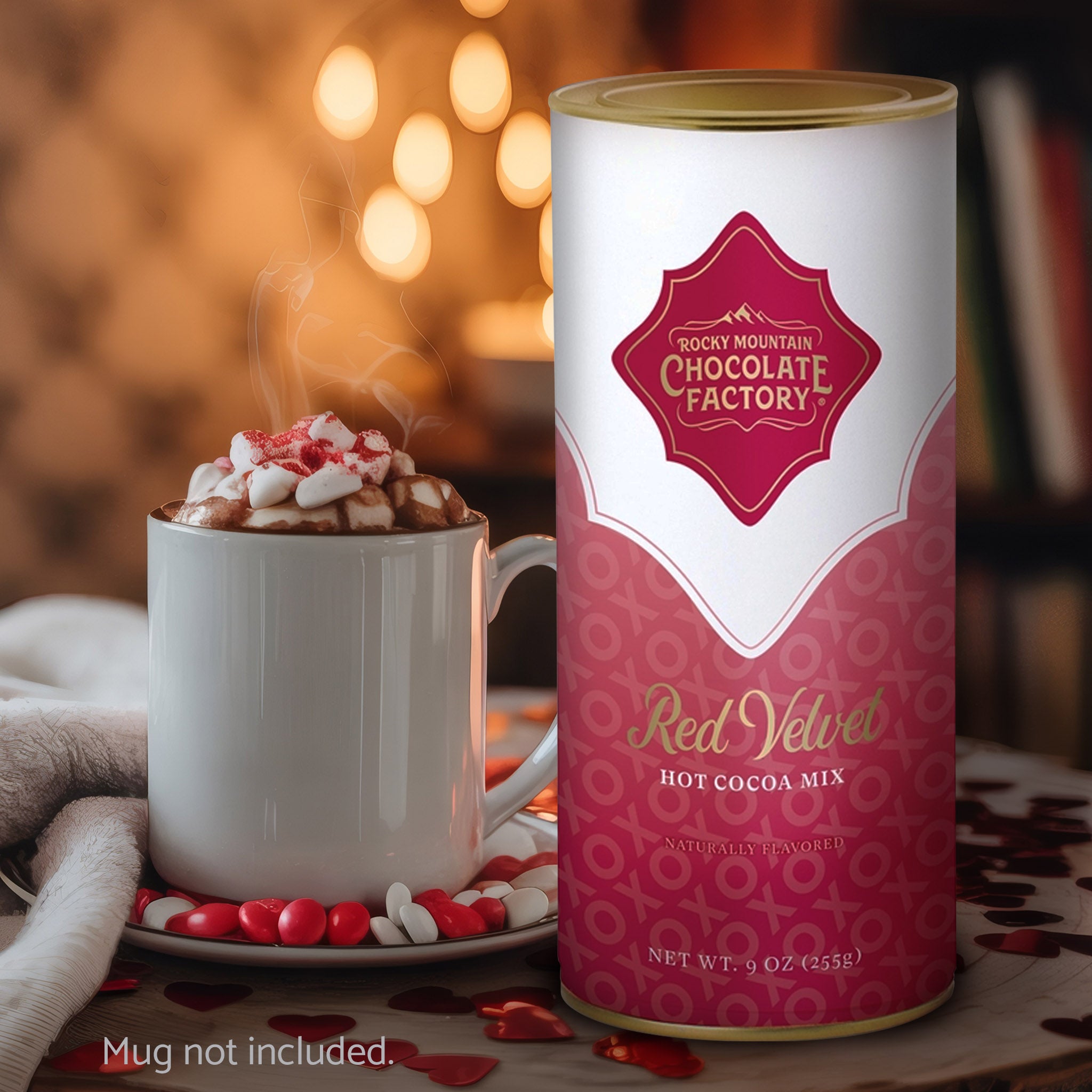 Canister of Rocky Mountain Chocolate Factory Red Velvet Hot Cocoa Mix with a steaming mug of hot cocoa.
